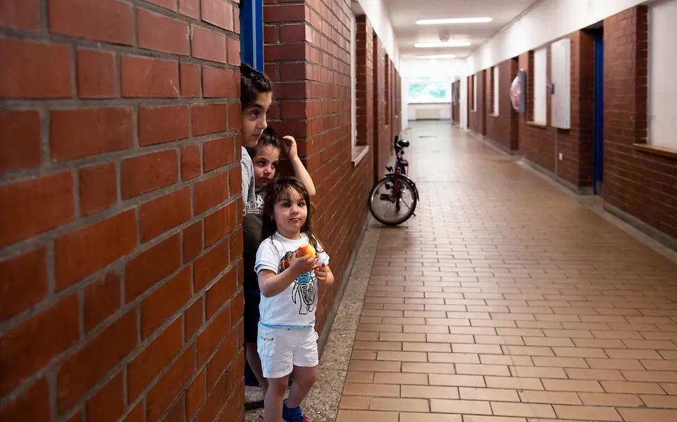 Drei Kinder stehen auf dem Flur einer Geflüchtetenunterkunft. UNI338416 Drei Kinder stehen auf dem Flur einer Geflüchtetenunterkunft.