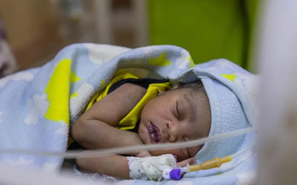 Ein mangelernährtes Baby bekommt in einem Krankenhaus eine Infusion | © UNICEF/UNI815691/Elfatih Sudan Krieg: Ein mangelernährtes Baby im Sudan bekommt in einem Krankenhaus eine stärkende Infusion.
