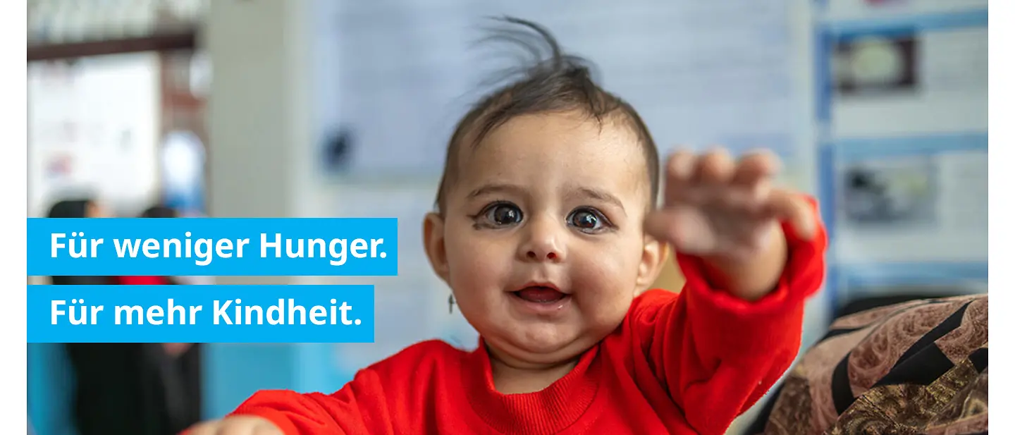 Unternehmen spenden zu Weihnachten: verspieltes Kleinkind im Ernährungsprogramm