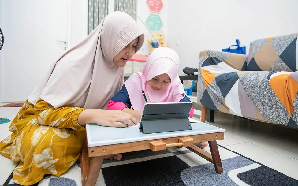 Eine Mutter in Indonesien zeigt ihrer Tochter zuhause etwas am Tablet. | © UNICEF/Wilander Digitale Gewohnheiten: Eine Mutter in Indonesien zeigt ihrer Tochter zuhause etwas am Tablet.