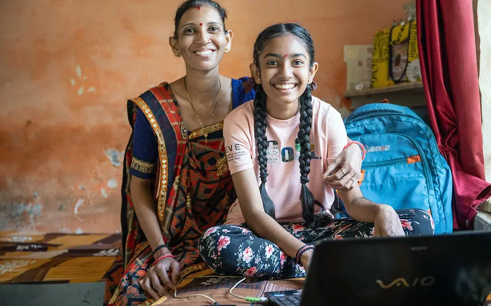 Ein Mädchen in Indien sitzt mit ihrer Mutter zuhause an einem Laptop. | © UNICEF/Panjwani Digitale Gewohnheiten: Ein Mädchen in Indien sitzt mit ihrer Mutter zuhause an einem Laptop.