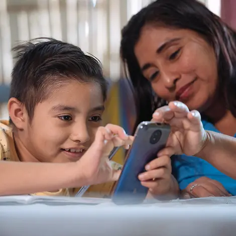 Ein Junge in Ecuador zeigt seiner Mutter etwas am Smartphone. | © UNICEF/Arcos Digitale Gewohnheiten: Ein Junge in Ecuador zeigt seiner Mutter etwas am Smartphone.