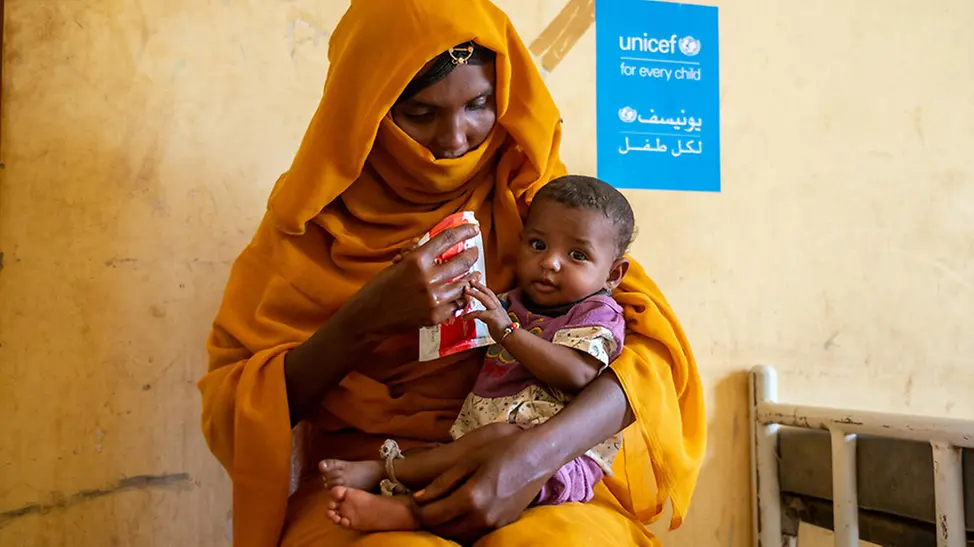 Sudan: Mutter gibt Kind Erdnusspaste. | © UNICEF/Rajab Sudan: Mutter gibt Kind Erdnusspaste.