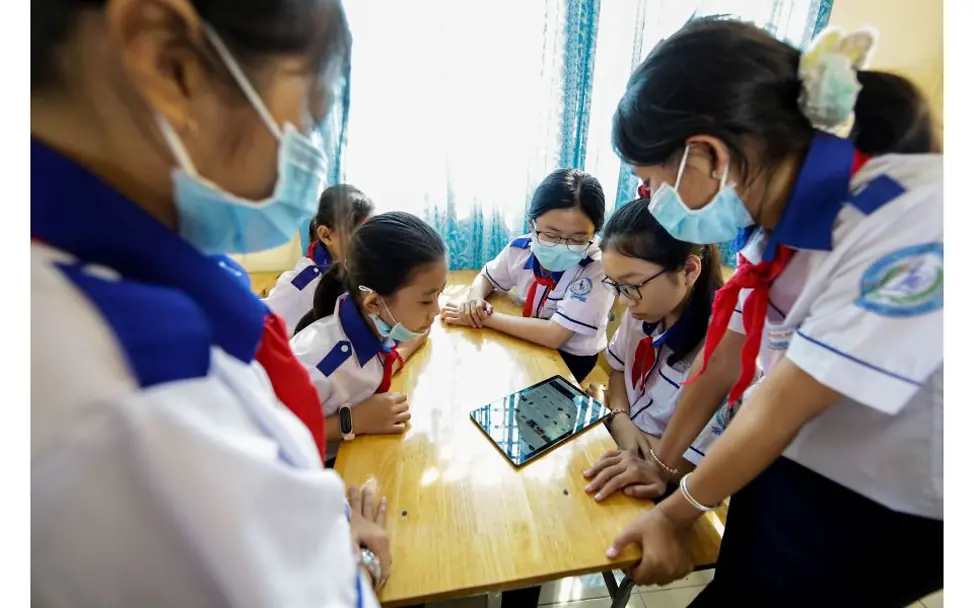 Vietnam: Schulmädchen sitzen an einem Tisch. 
