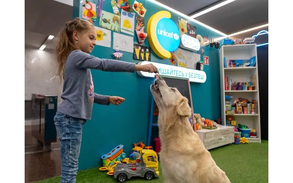 Ukraine: Mädchen spielt mit Hund.