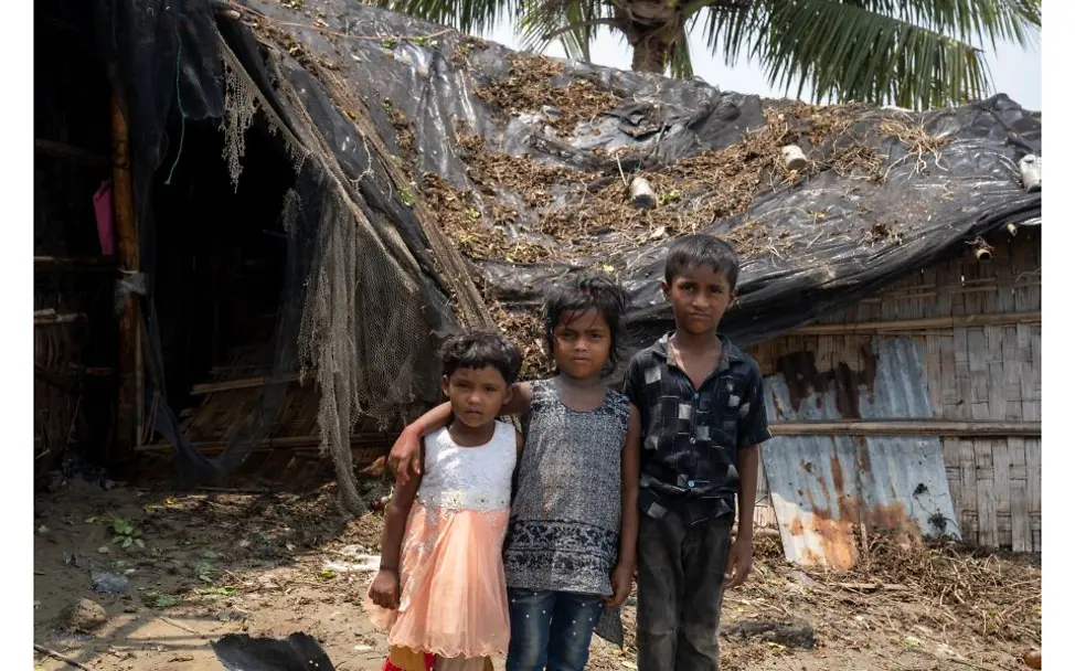 Kinder stehen vor einem durch Zyklon zerstörtem Haus.