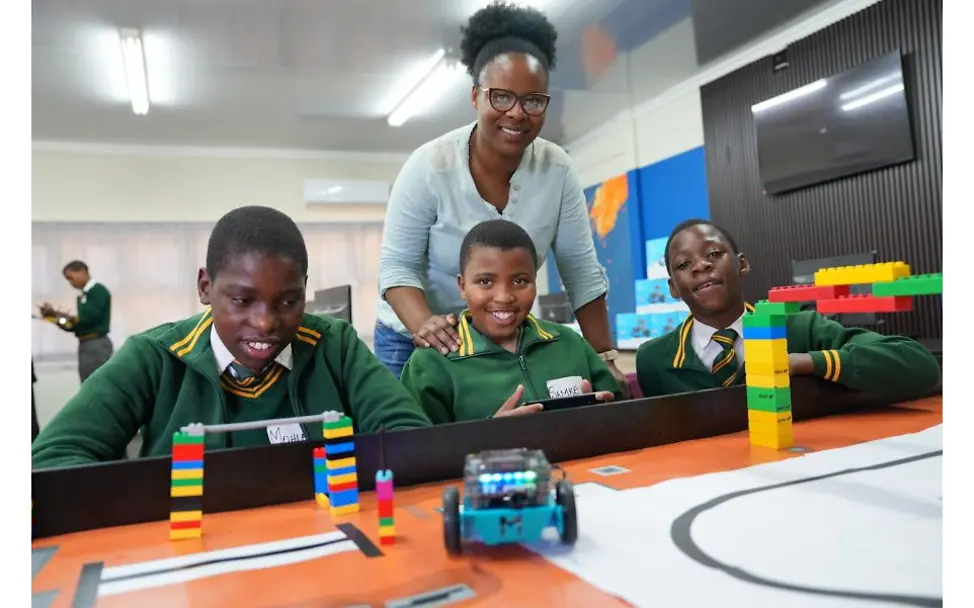 3 Schüler und ihre Lehrerin an einem Tisch.