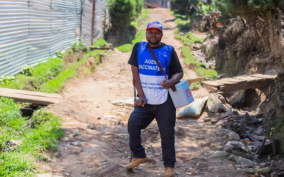 Polio in der DRC: Sozialarbeiter Zawadi Kasereka trägt eine Kühlbox mit Impfstoffen