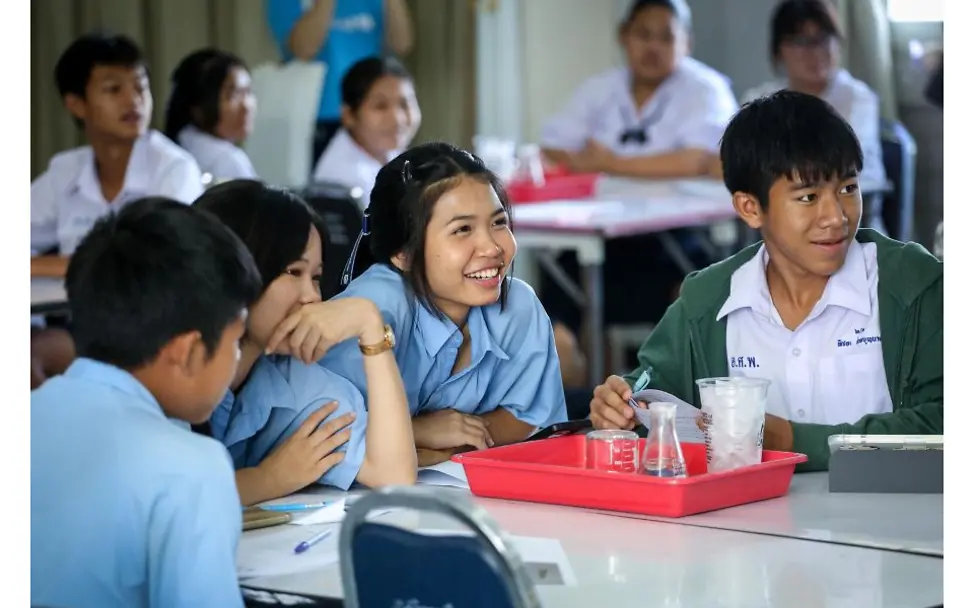 Thailand: Schüler*innen sitzen an einem Tisch und machen ein Experiment.