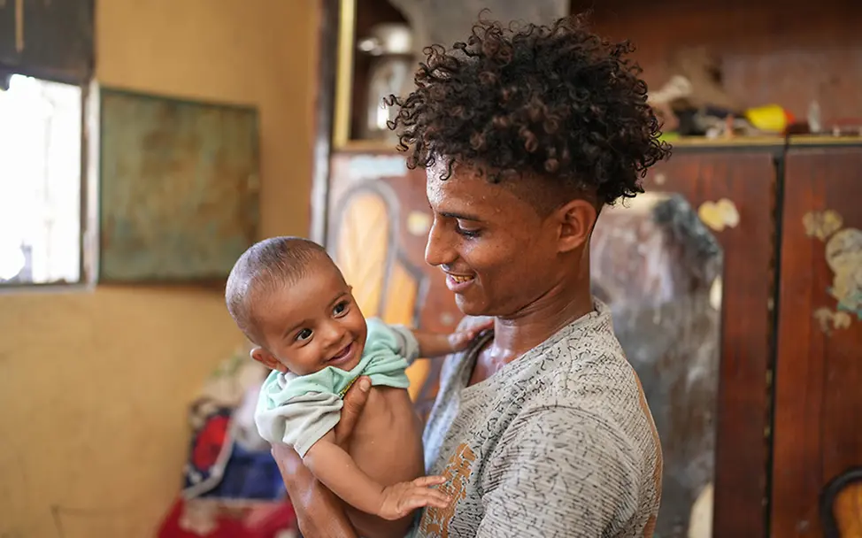 Jemen: Baby wird von seinem Vater gehalten.