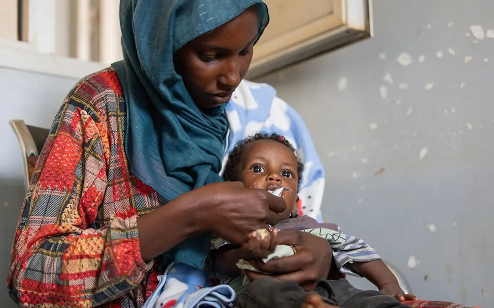 Eine Mutter füttert ihren sieben Monate alten Sohn mit therapeutischer Spezialnahrung.
