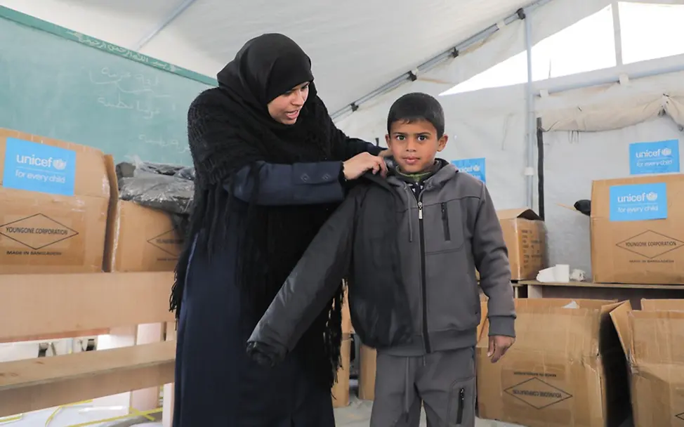 Verteilung von warmer Kleidung | UNICEF/Nateel Kinder in Gaza: Mohammed (8) zieht eine Winterjacke an
