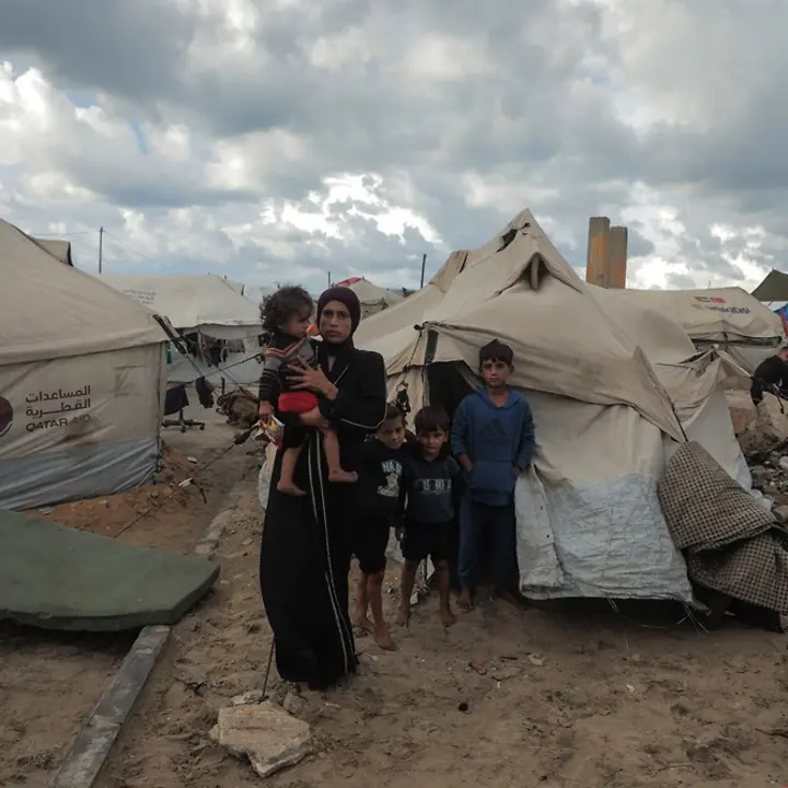 Maysaa lebt mit ihren Kindern in einem Zelt | UNICEF/Nateel Maysaa steht mit ihren Kindern vor einem provisorischen Zelt