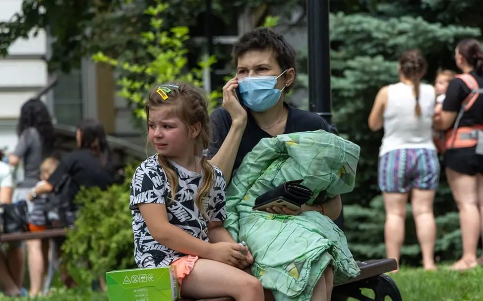 Kiew: Ein Mädchen sitzt weinend neben seiner Mutter 