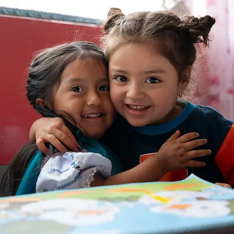 Zwei lächelnde Mädchen in Ecuador umarmen sich innig | © UNICEF/Arcos Jahresrückblick 2025: Unsere Highlights im vergangenen Jahr.