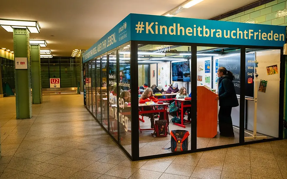 Klassenzimmer in Berliner U-Bahn-Station Alexanderplatz | © UNICEF/Zimmermann Klassenzimmer in der Berliner U-Bahn-Station Alexanderplatz, um auf die Lage der Kinder in der Ukraine aufmerksam zu machen.