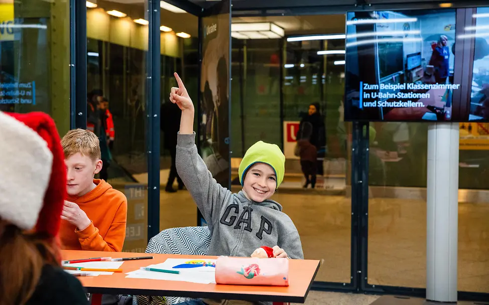 Unsere nachgebaute U-Bahn Schule am Berliner Alexanderplatz. | © UNICE/Zimmermann Ein Schüler der Jenaplan-Schule Neukölln meldet sich.