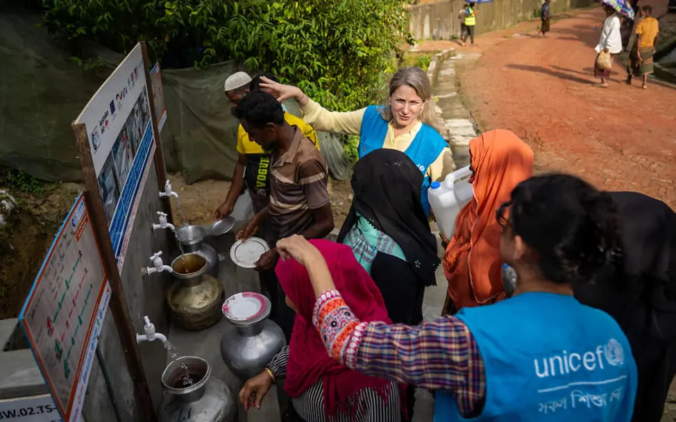 Rohingya in Bangladesch: Sauberes Wasser ist entscheidend, um die Ausbreitung von Krankheiten im Camp zu vermeiden. | © UNICEF/Mukut Rohingya Flüchtlingslager: UNICEF-Helfer*innen zeigen Rohingya die Wasserversorgung im Flüchtlingscamp.