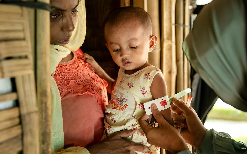 Rohingya in Bangladesch: Viele Kinder im Rohingya-Camp sind mangelernährt und daher anfälliger für Krankheiten. | © UNICEF/Njiokiktjien Rohingya Flüchtlingslager: Ein Kleinkind auf dem Arm seiner Mutter wird auf Mangelernährung getestet.