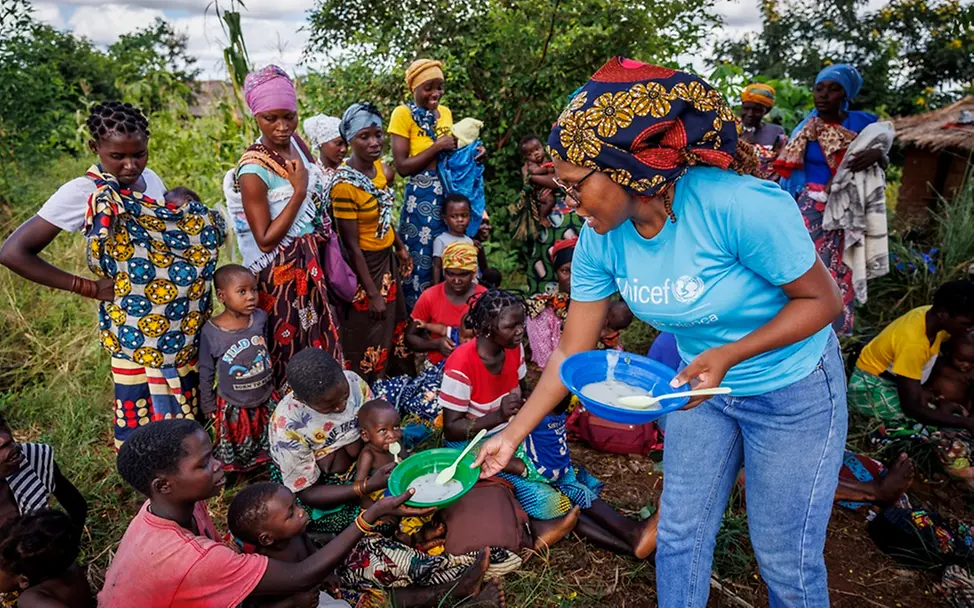 Überschwemmungen Mosambik: Eine UNICEF-Helferin verteilt Essensschalen