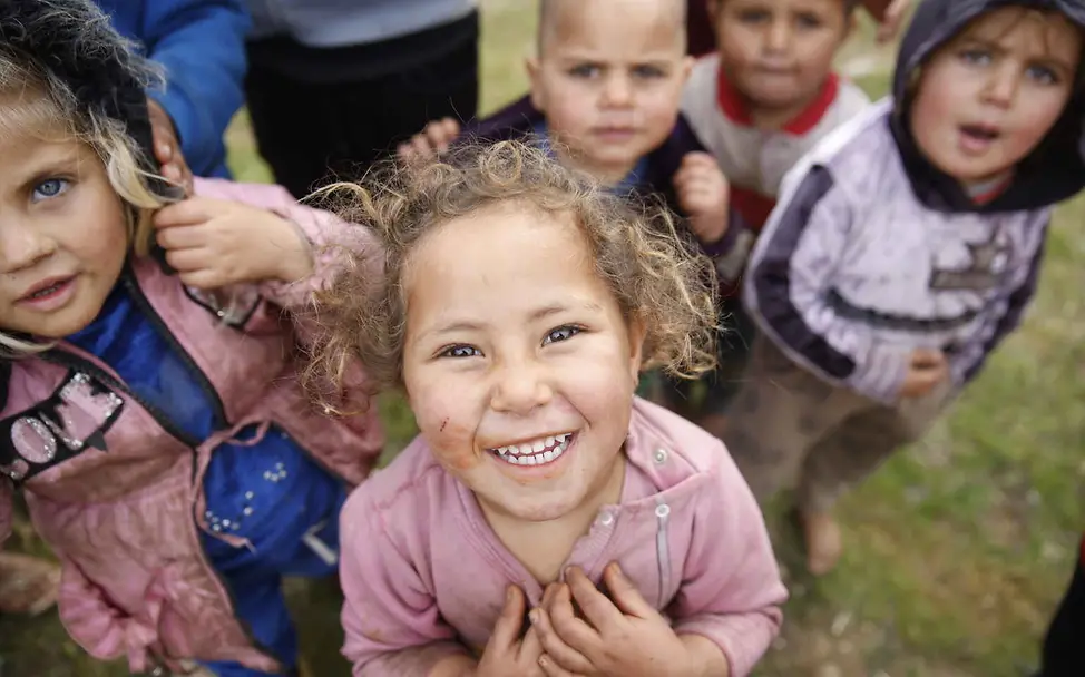 Menschenrechte einfach erklärt: Alle Menschen haben das Recht, frei und sicher zu leben. Menschenrechte einfach erklärt: Kinder blicken lachend in die Kamera.