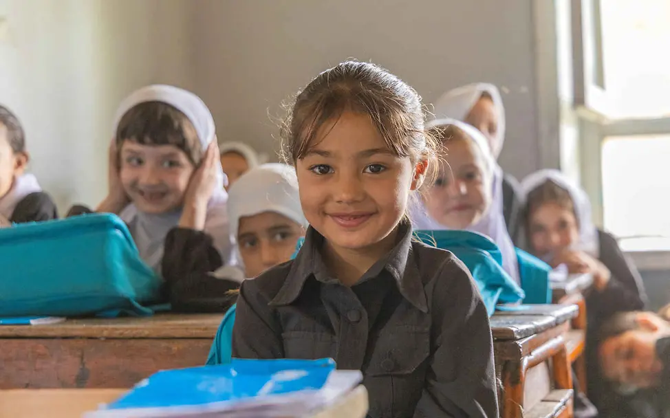 Menschenrechte einfach erklärt: Jeder Mensch auf der Welt hat das Recht, zur Schule zu gehen und seinen Lebensunterhalt zu verdienen Menschenrechte einfach erklärt: Mädchen sitzen in ihrer Klasse an Schultischen