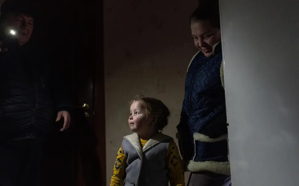 Dasha (3) steht warm eingepackt neben ihrer Mutter Iryna in der Wohnung. | © UNICEF/Filippov Ukraine Krieg: Dasha (3) steht warm eingepackt neben ihrer Mutter Iryna in der Wohnung.