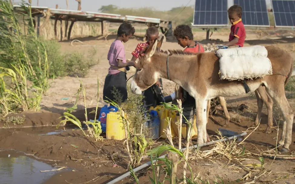 Kinderholen Wasser aus einer Wasserstelle in der Nähe ihres Hauses.