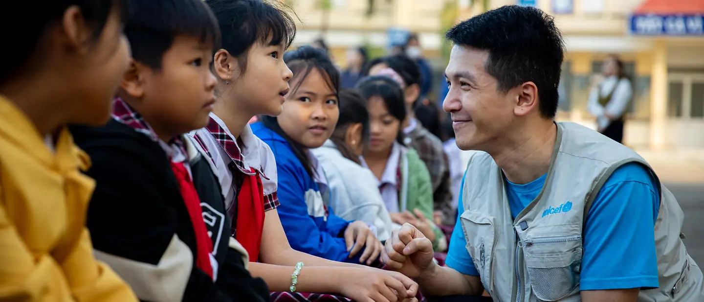 Ein UNICEF-Mitarbeiter unterhält sich mit Grundschülerinnen und -schülern | © UNICEF/Luu Thu Huong UNICEF in Vietnam: Ein UNICEF-Helfer besucht nach einer Überschwemmung eine Grundschule