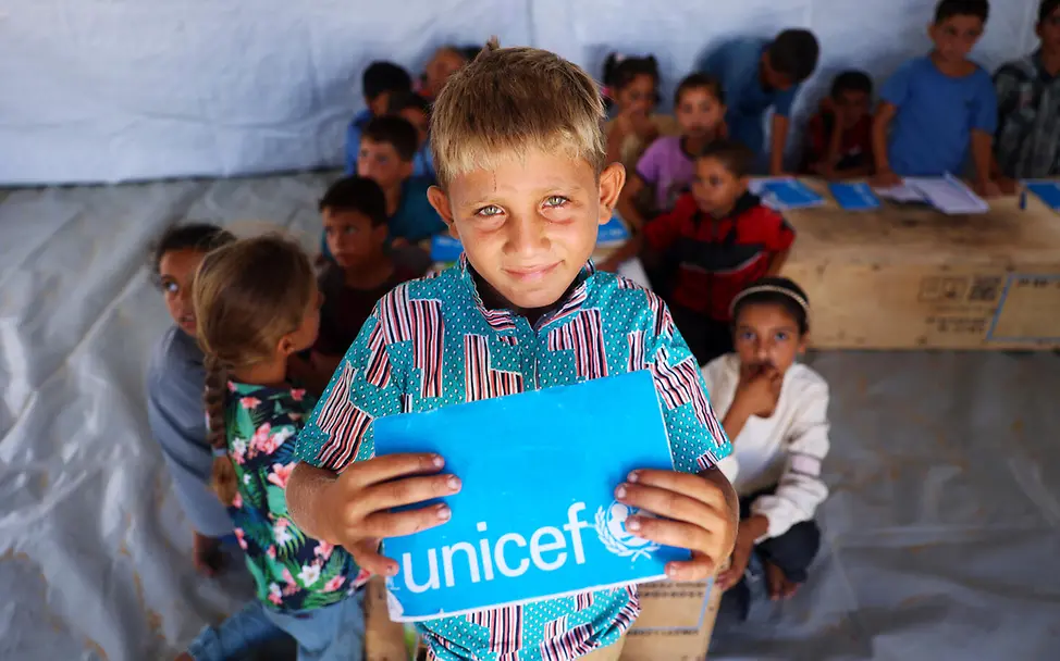 Gaza spenden: Ein Junge zeigt in einem Lernzentrum sein UNICEF-Schulheft. 