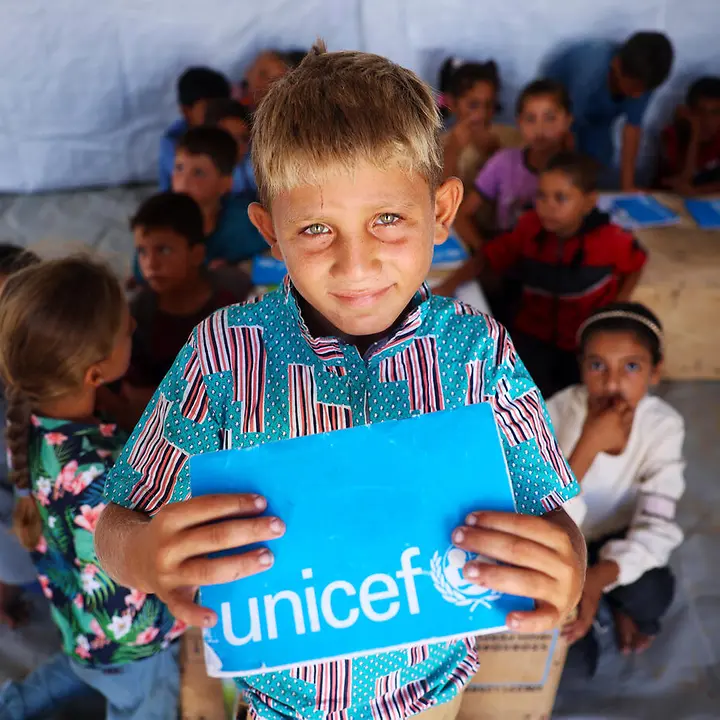 Der 10-jährige Ibrahim hält sein UNICEF-Schulheft in den Händen. | © UNICEF/Nateel Gaza spenden: Ein Junge zeigt in einem Lernzentrum sein UNICEF-Schulheft.