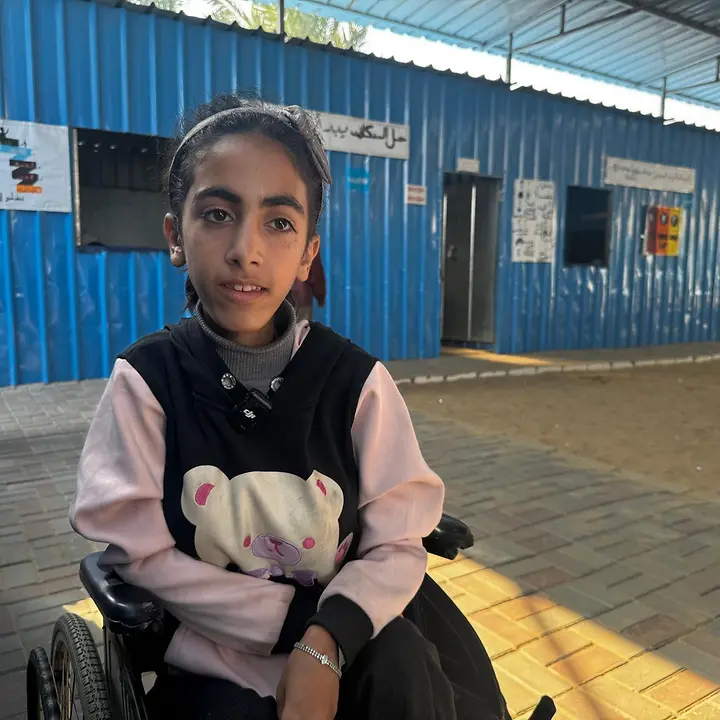 Jana, 13, wird in ihrem Rollstuhl zur Schule gebracht. | © UNICEF/Eleyan Gaza spenden: Ein Mädchen in einem Rollstuhl.