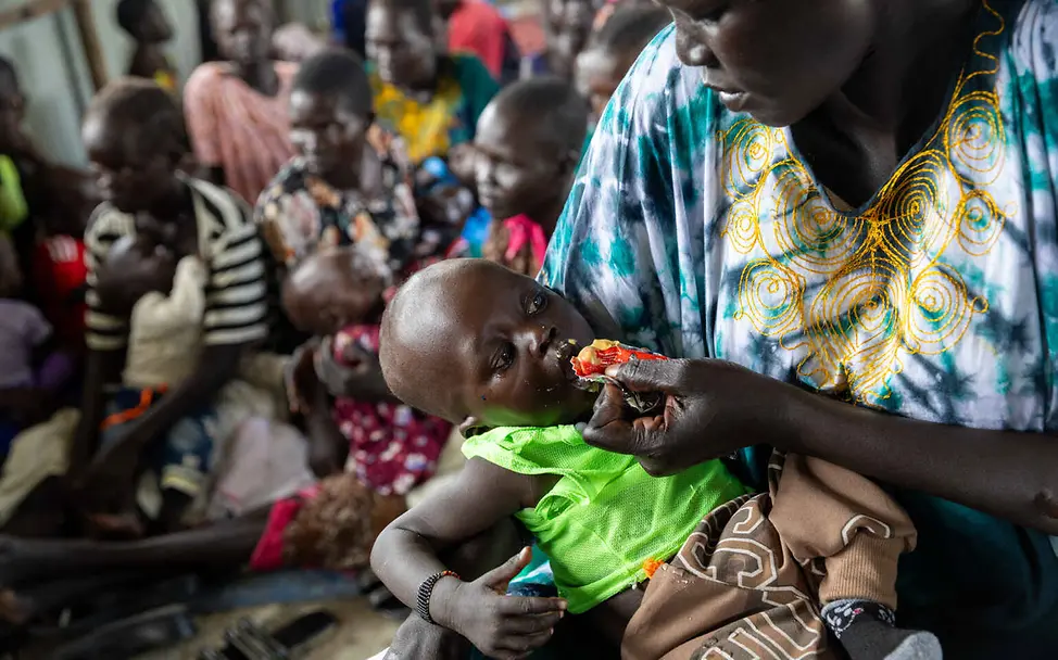 Hunger im Südsudan: Einfache Hilfsgüter wie Spezialmilch und Erdnusspaste helfen mangelernährten Kindern. | © UNICEF/Prinsloo Südsudan Hungerkrise: Eine Mutter füttert ihr Kleinkind mit Erdnusspaste.