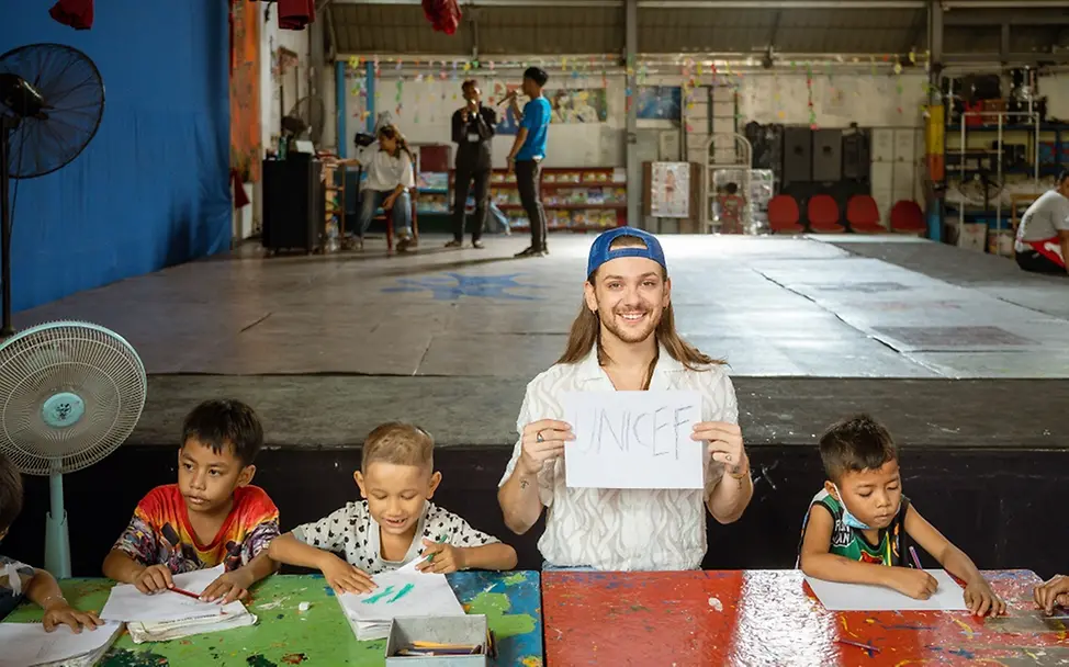 Riccardo Simonetti lernt die Mal-Ecke im von UNICEF finanzierten Bildungszentrum kennen