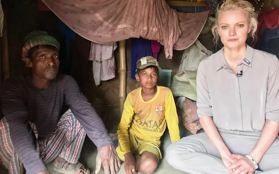 Franziska Knuppe in Bangladesch | © UNICEF/UNI277624/Berger Drei Personen sitzen auf dem Boden und blicken in die Kamera