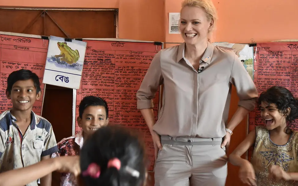 Franziska Knuppe in einem Kinderschutzzentrum | © UNICEF/UNI277366/Berger Eine Frau und mehrere Kinder lachen fröhlich miteinander