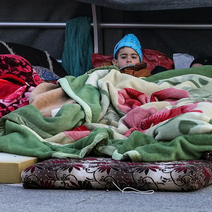 Ein geflüchteter Junge im südlichen Libanon liegt unter einer Decke | © ANWAR AMRO / AFP Libanon spenden: Ein geflüchteter Junge im südlichen Libanon liegt unter einer Decke.