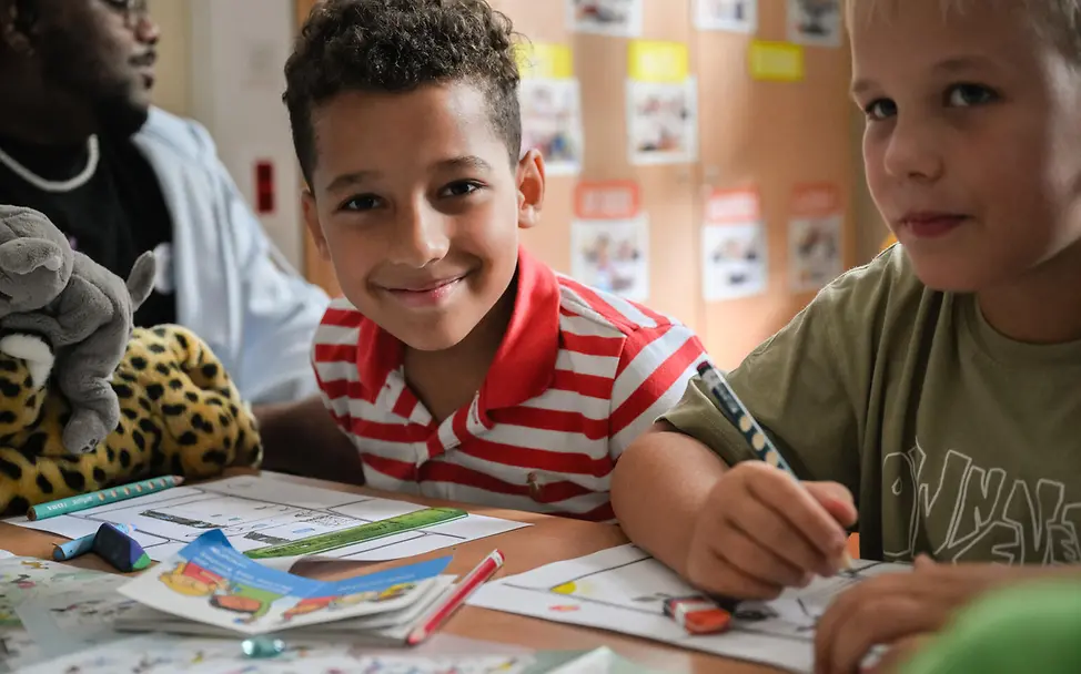Weltkindertag Kindern erklären: UNICEF arbeitet am Weltkindertag mit Kindern in Schulen. | © UNICEF/PaulaGVidal Weltkindertag einfach erklärt: Jungen sitzen mit Malsachen an einem Schultisch.