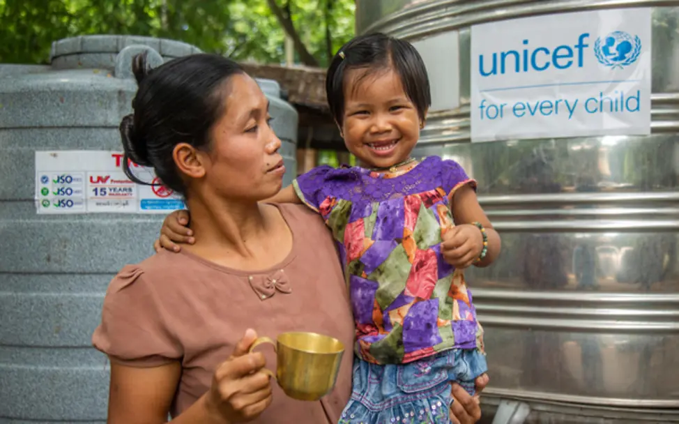 Mutter und Kind trinken sauberes Wasser aus UNICEF-Tank in Sagaing