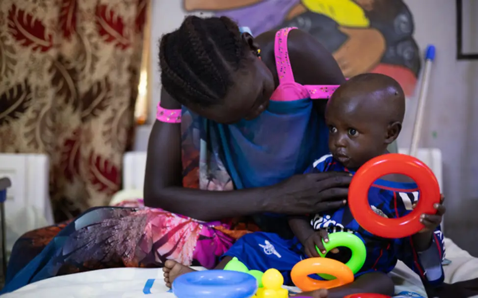Genesendes Kleinkind Tito (15 Monate) spielt mit seiner Mutter im Krankenhaus