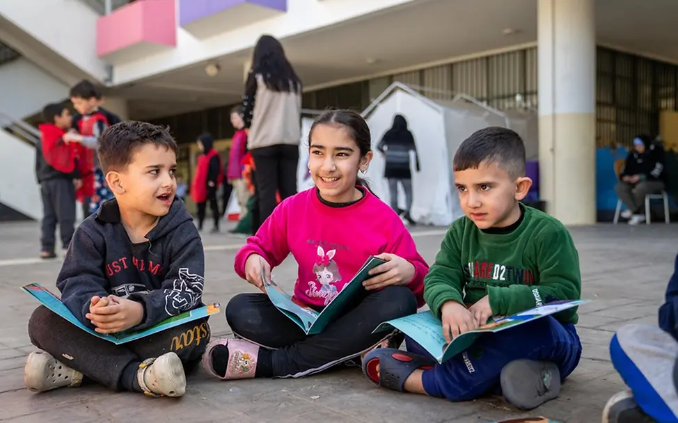 Leben im Libanon: Asil (11) liest mit Freunden in einer Notunterkunft.