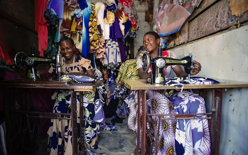Gute Nachricht: Antini und ihre Mentorin Ester nähen gemeinsam auf einem Markt in Tansania.