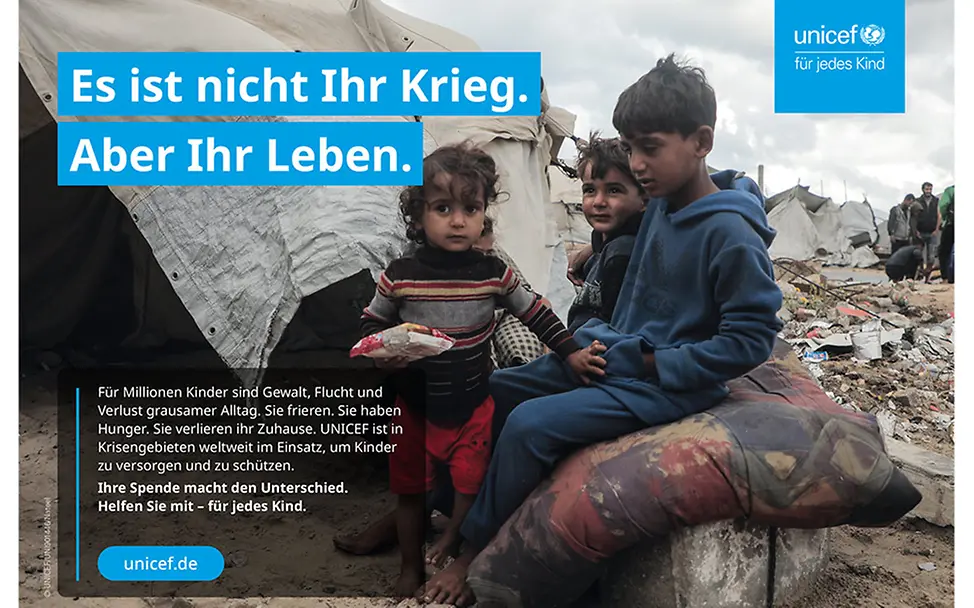In Gaza sitzen drei Kinder vor einem Zelt.