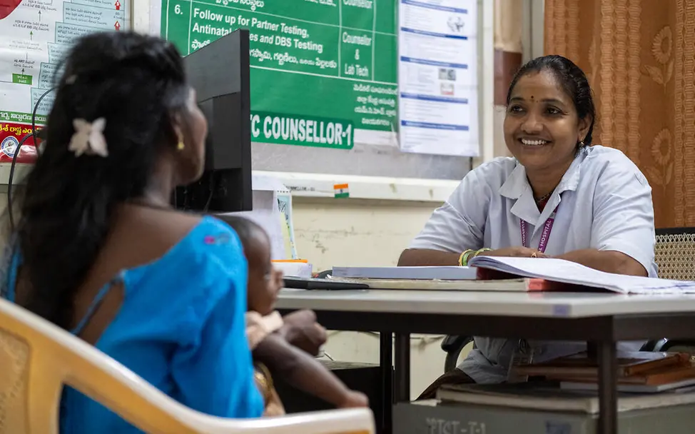 Was ist Aids: Eine Gesundheitshelferin berät eine HIV-positive Mutter. 