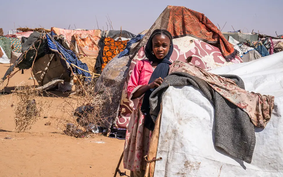 Mädchen steht zwischen Zelten