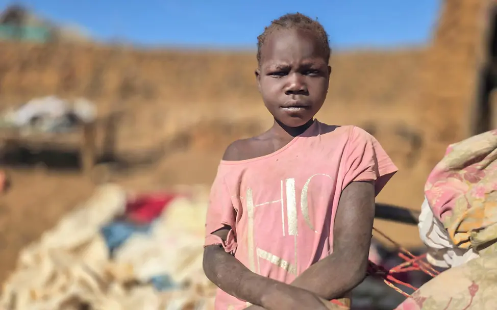 Mädchen sitzt vor provisorischem Zuhause