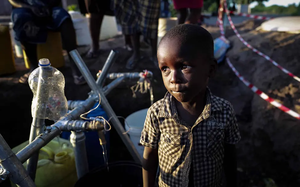 Mosambik Überschwemmungen: Ein Junge steht vor einer improvisierten Trinkwasserleitung.