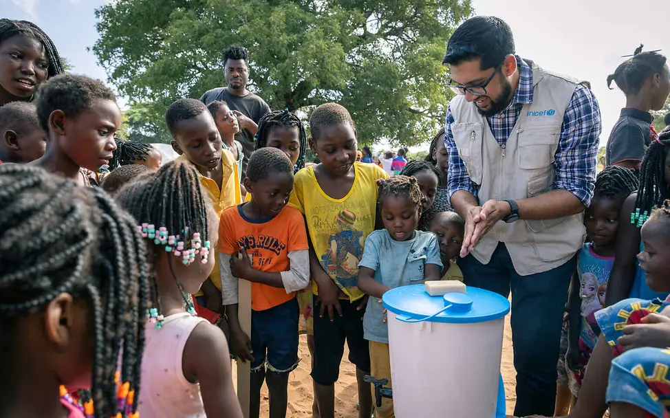 Mosambik Überschwemmungen: Ein UNICEF-Helfer wäscht gemeinsam mit Kindern die Hände.