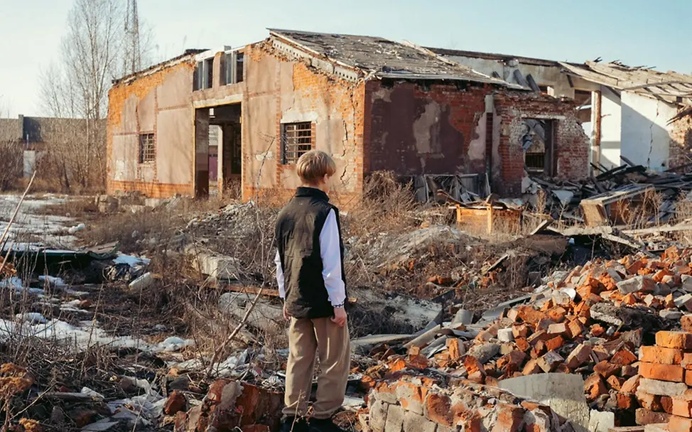 Roman (13) schaut auf die Trümmer eines Kinderzentrums und eines Cafés.
