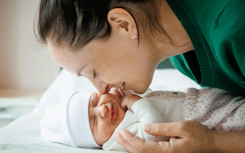 Impfungen Baby: Eine Mutter kuschelt mit ihrem Baby. 